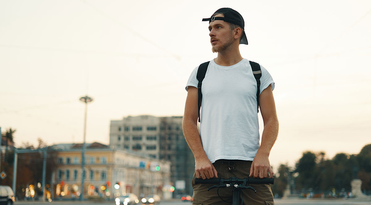 Bewegungsdaten: Ein junger Mann mit Basecap auf dem Fahrrad, im Hintergrund eine Stadtkulisse