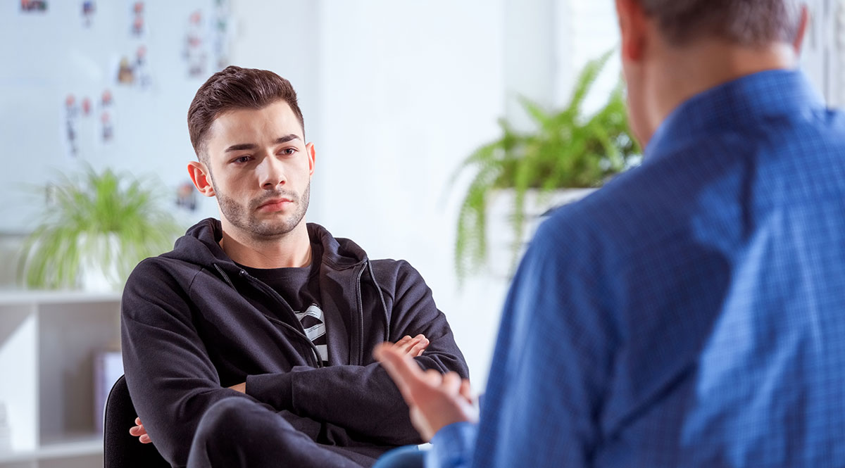 Ein junger Mann sitzt in einem Beratungsgespräch 