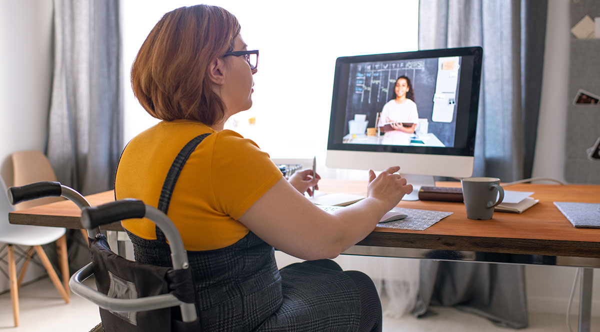 Eine Frau im Rollstuhl arbeitet im Homeoffice 