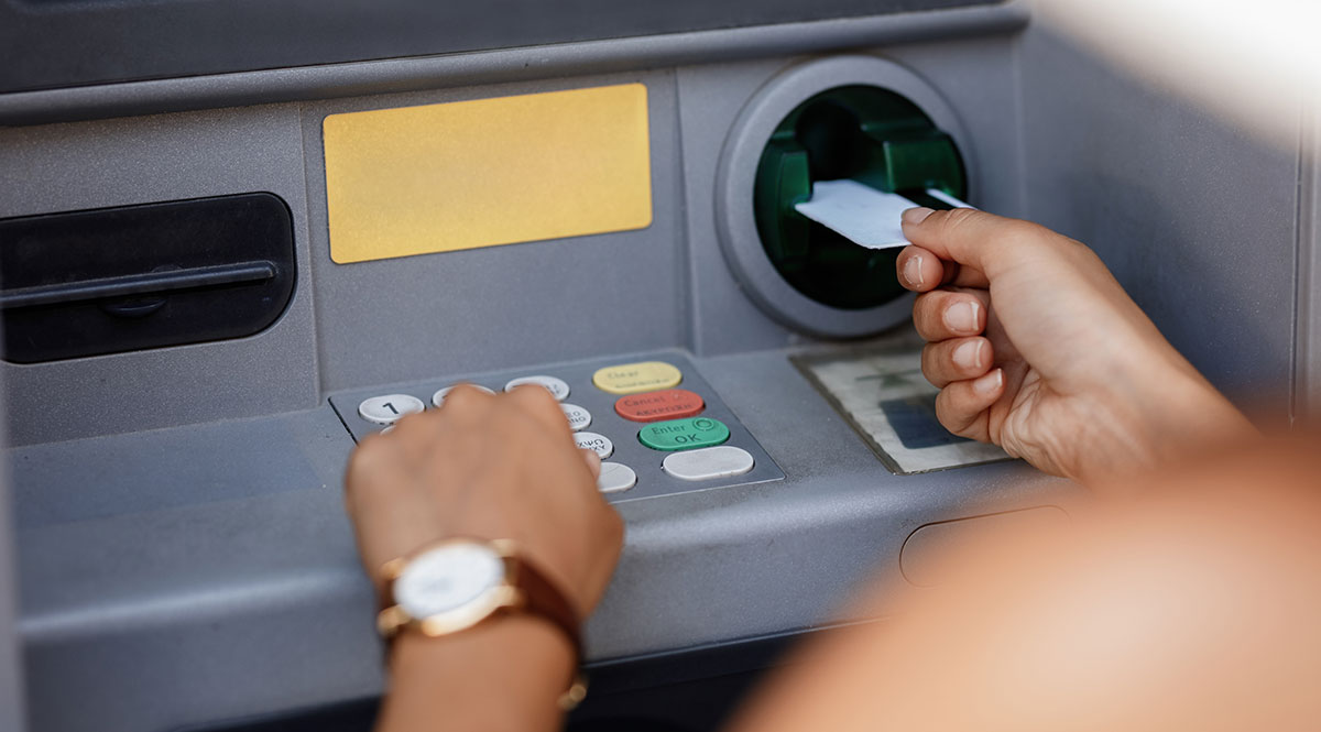 Jemand hebt Geld an einem Bankautomaten ab