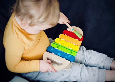 Ein kleines Kind spielt mit einem Glockenspiel