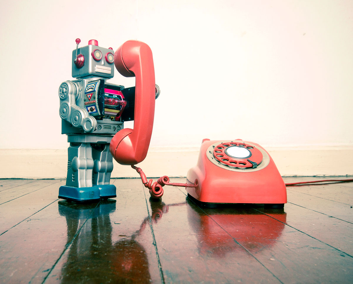 Spielzeug-Roboter telefoniert mit altem Wählscheibentelefon