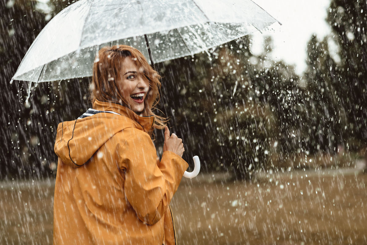 Junge Frau mit Regenschirm im Regen
