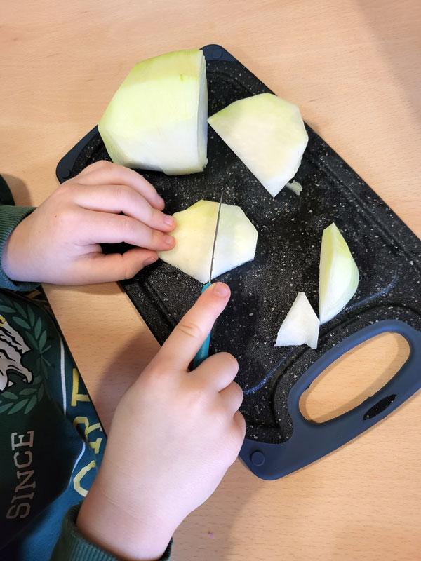 Kinderhände beim Schneiden von Kohlrabi