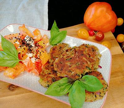 Brotfrikadellen auf einem Teller mit Tomatensalat 