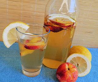 Zitronen-Pfirsich-Wasser in einer Karaffe, Obstdekoration