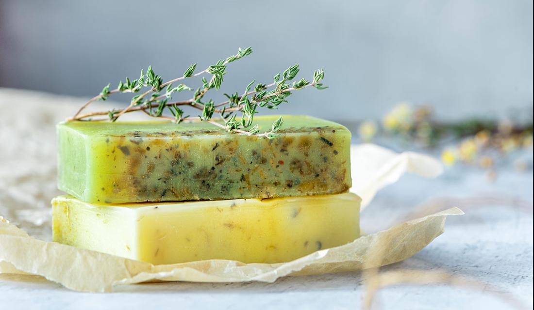 Zwei Stück selbstgemachte Seife mit einem Kräuterzweig dekoriert