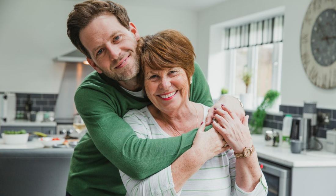 Mann umarmt ältere Frau