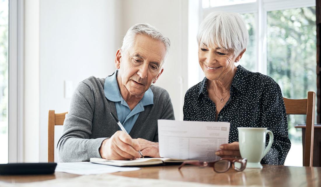 Betreuungsverfügung: Ein älteres Paar sitzt am Tisch und arbeitet an einem Dokument