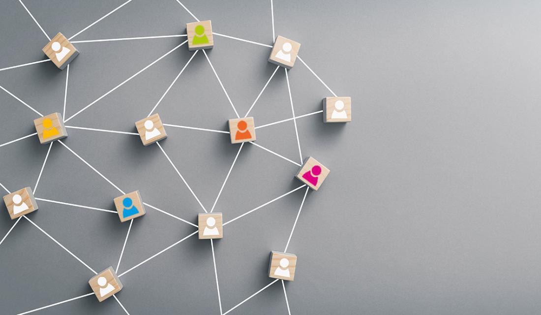 Kleine Holzplättchen mit Personen-Icons sind durch Schnüre miteinander vernetzt