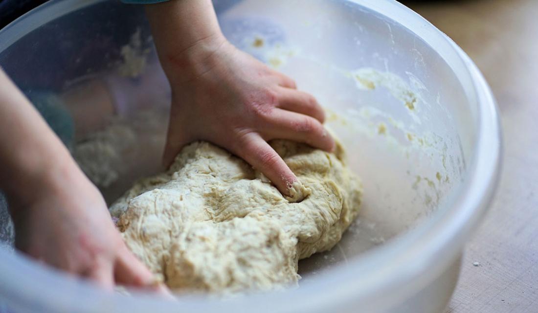 Kinderhände kneten Teig in einer Schüssel