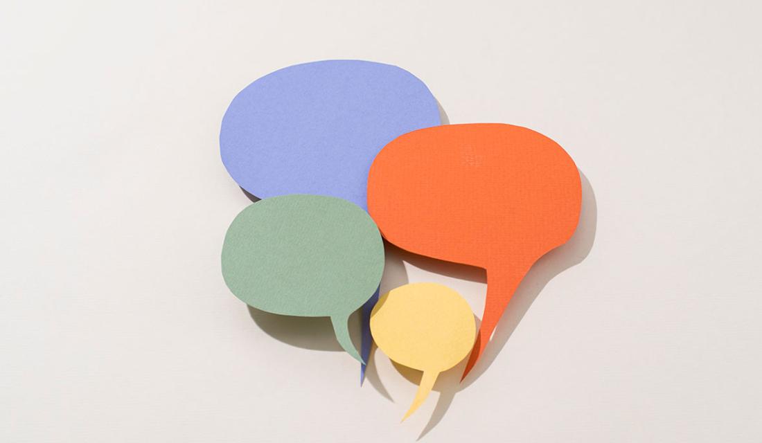 Vier verschieden farbige Sprechblasen als Symbol für verschiedene Sprachen 