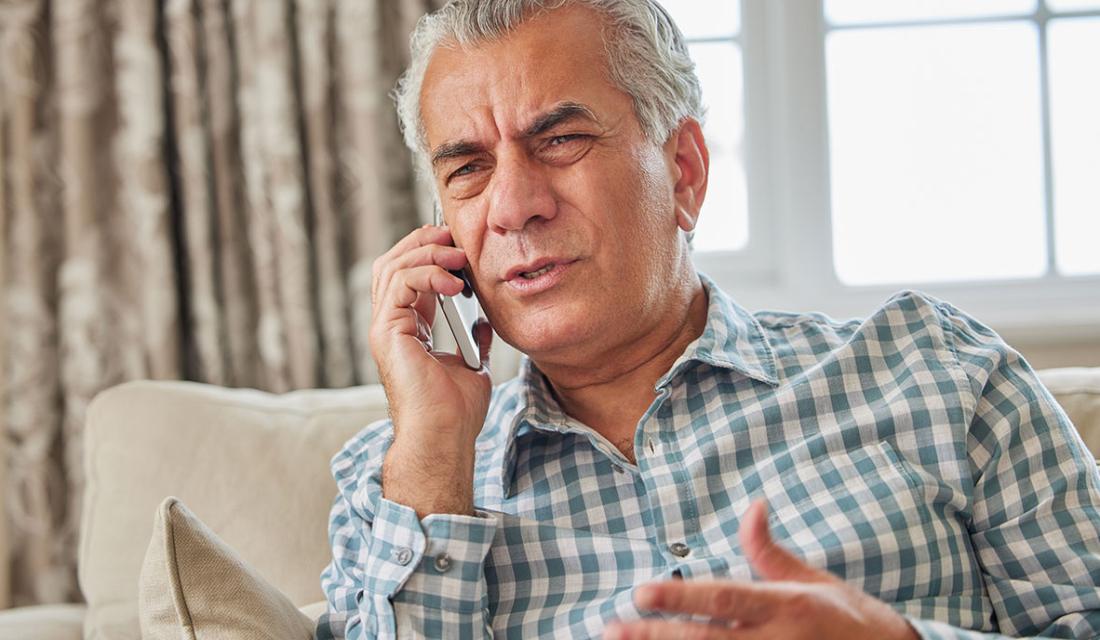 Ein älterer Mann verärgert am Telefon