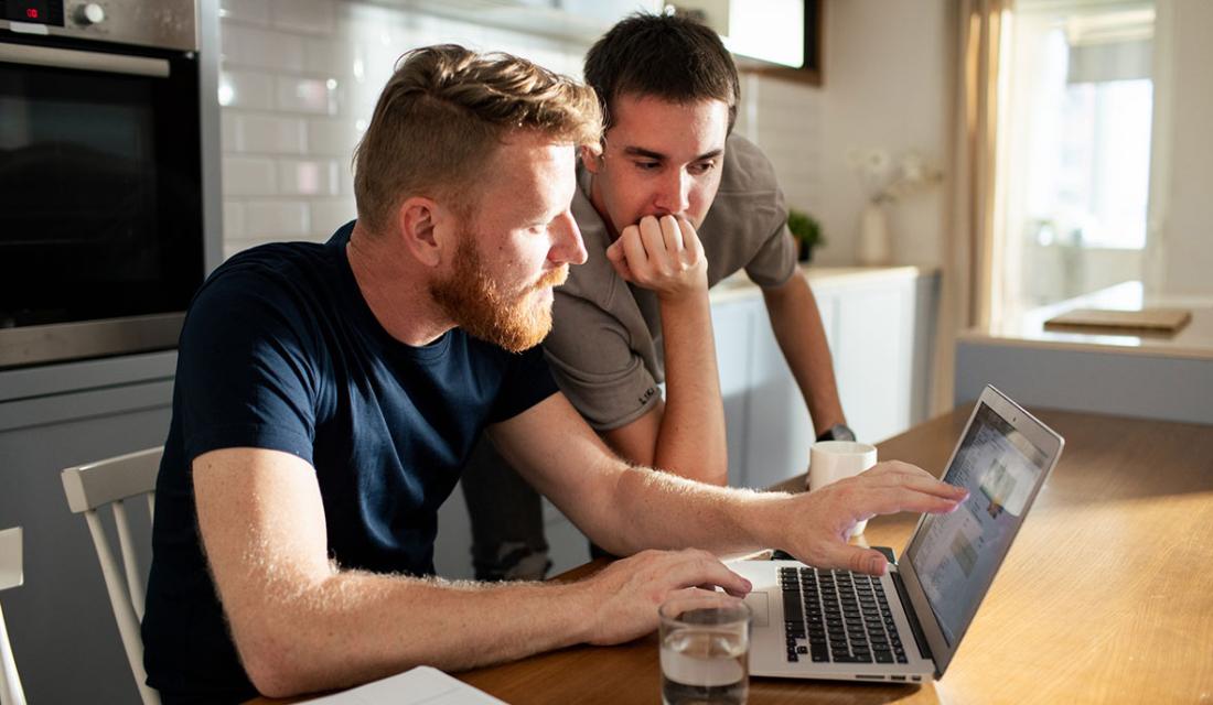 Zwei Männer sitzen vor einem Laptop