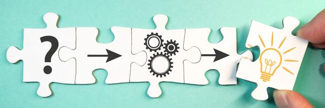 Jemand legt Puzzleteile aneinander, auf denen die Symbole Fragezeichen, Zahnräder und Glüclampe zu sehen sind