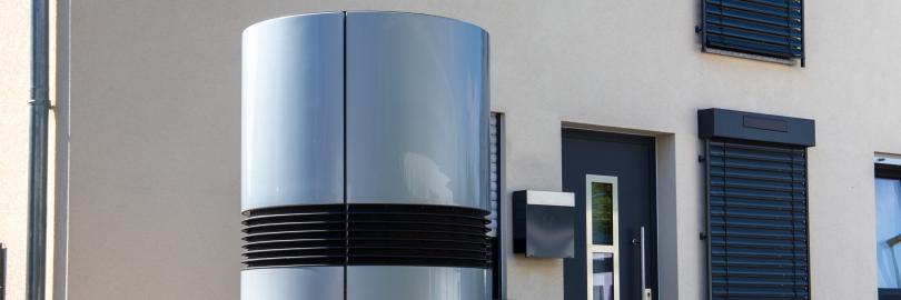 Eine moderne Luft-Wasser-Wärmepumpe vor einem Einfamilienhaus