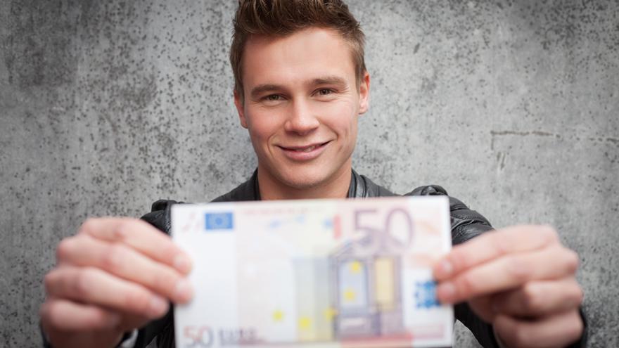 Jugendlicher hält einen 50-Euro-Schein in der Hand