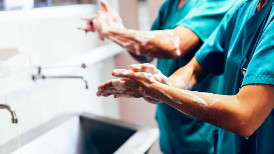 Zwei Chiriurgen reinigen sich vor einer Operation die Hände