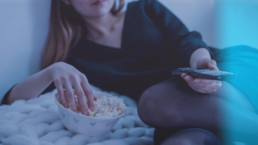 junge Frau schaut TV mit Popcorn