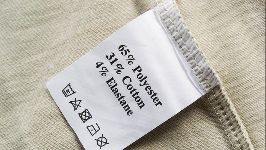 Ein Wäscheschild mit den Angaben "65% Polyester, 31% Cotton, 4% Elasthane"