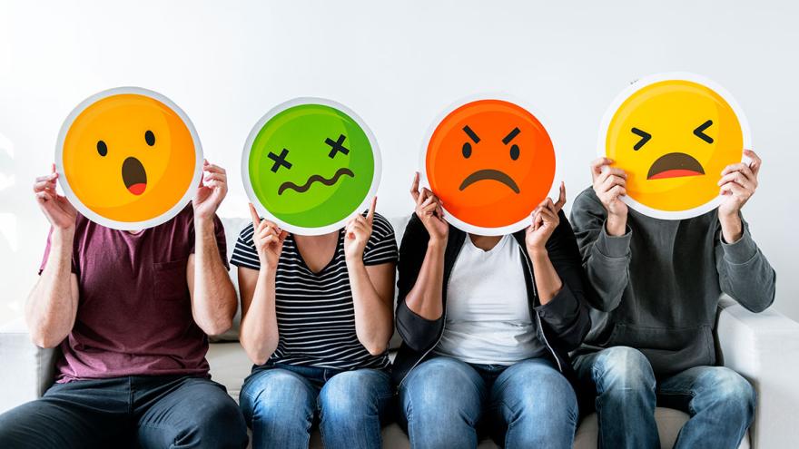 Vier Menschen halten Emoticons vor ihre Gesichter: erschrocken, verzweifelt, wütend, traurig