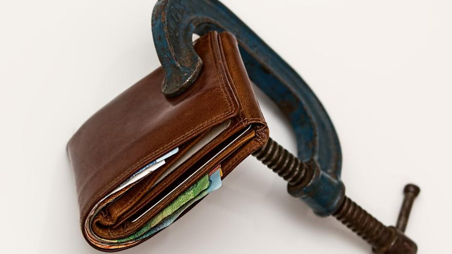 Kreditklemme: Eine Geldbörse ist in einen Schraubstock eingespannt 