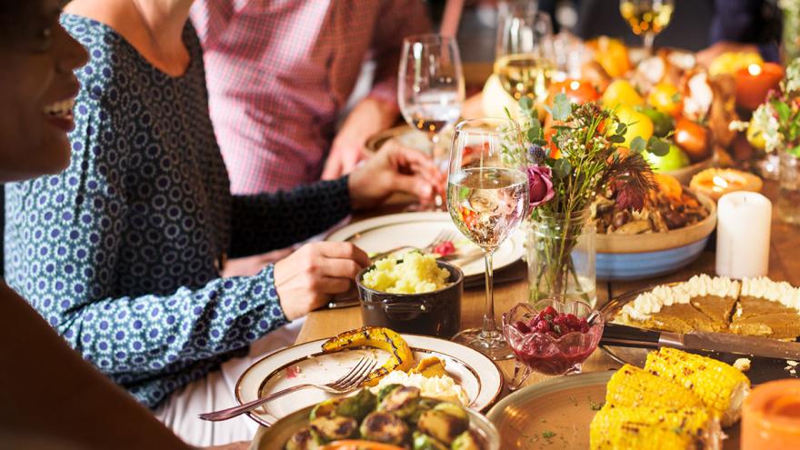 Weihnachten ohne Essensreste feiern mit guter Planung und Resteverwertung: Ein Festessen, mehrere Menschen sitzen am Tisch