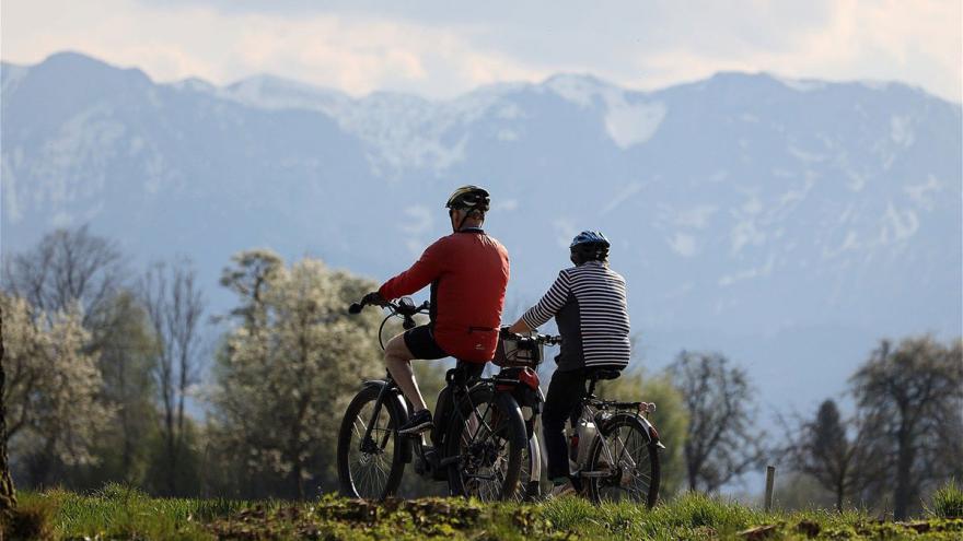 Ein älteres Paar auf E-Bikes in den Bergen