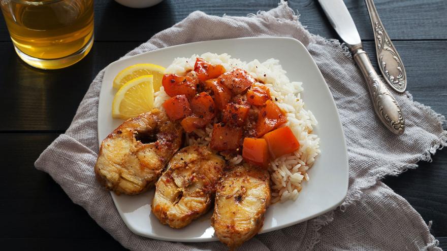 Ein Teller mit gebratenen Fischsteaks, reis und Gemüse