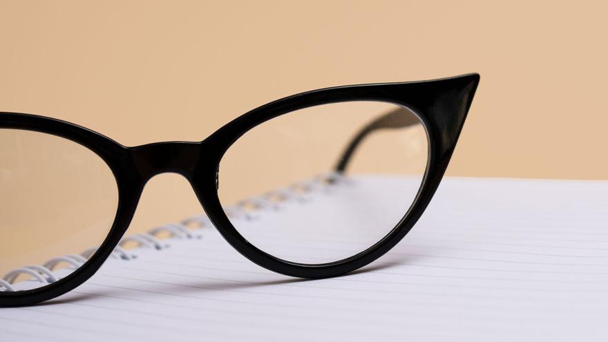 Eine schwarze Brille liegt auf einem Schreibblock