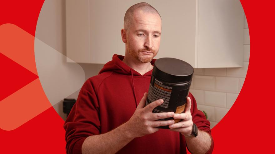 Mann hält Proteinpulver in der Hand