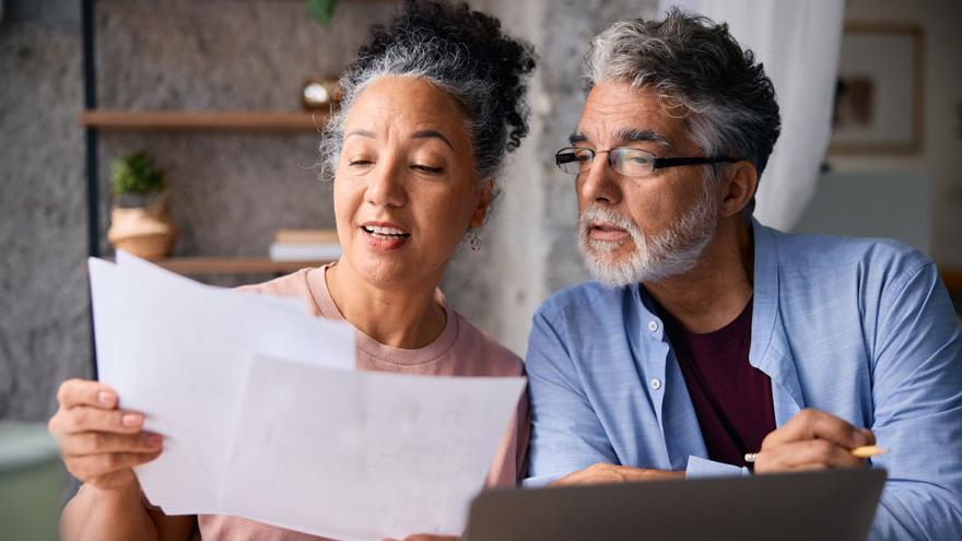 Ein Mann und eine Frau mittleren Alters schauen gemeinsam auf Unterlagen