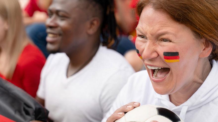Nahaufnahme eines weiblichen Fußballfans mit bemaltem Gesicht