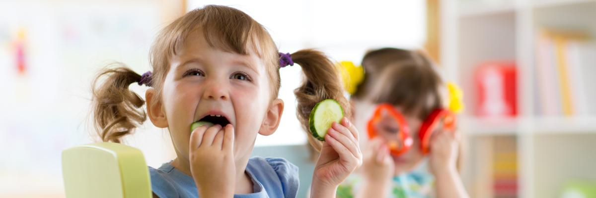 Kita-Kinder essen Gurken und Paprikascheiben