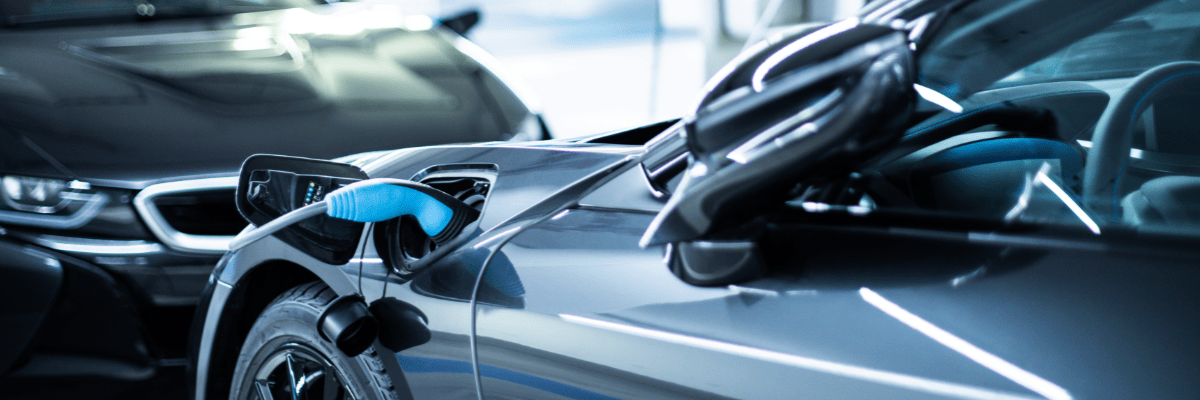 Zwei Elektroautos stehen sich gegenüber, eins wird geladen.