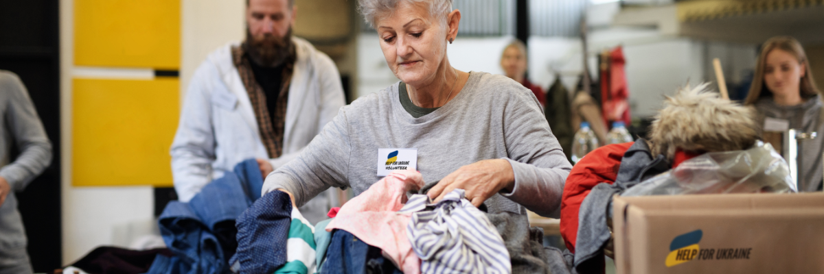 Mehrere Personen packen Hilfspakete mit der Aufschrift "Help for Ukraine".