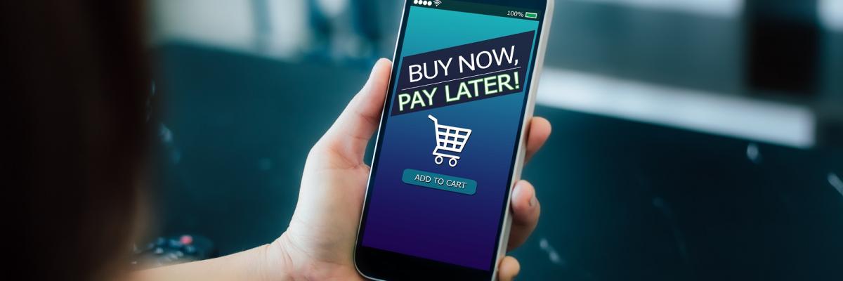 Auf einem Handy wird ein Screen mit der Aufschrift "Buy now, pay later" angezeigt.