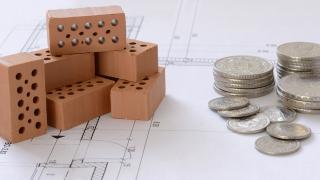 Münzen auf einem Bauplan