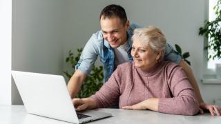 Seniorin und Sohn am Laptop