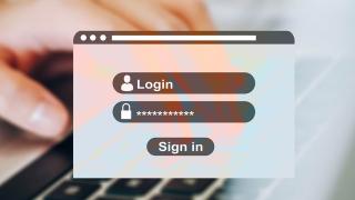 Hände liegen auf einer Tastatur, davor ist ein Login-Fenster eingeblendet