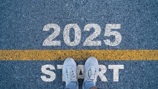 Jemand steht auf einer Straße, auf der eine Startlinie für das Jahr 2025 aufgemalt ist 