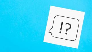 Ein Ausrufezeichen und ein Fragezeichen in einer Sprechblase auf hellblauem Grund symbolisieren Fragen und Antworten