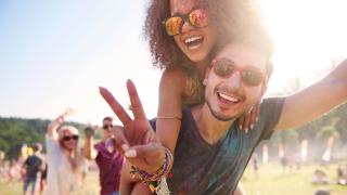 Fröhliche Besucher auf einer Wiese bei einem Festival