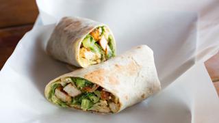 Zwei Hälften eines Wraps liegen auf einem weißen Teller