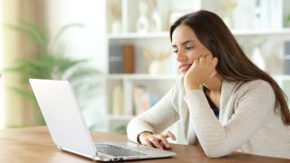 Gelangweilte Person vor einem Laptop