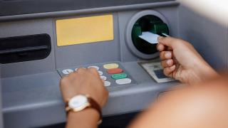 Jemand hebt Geld an einem Bankautomaten ab