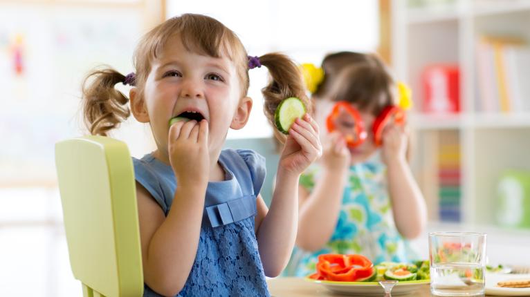 Kita-Kinder essen Gurken und Paprikascheiben