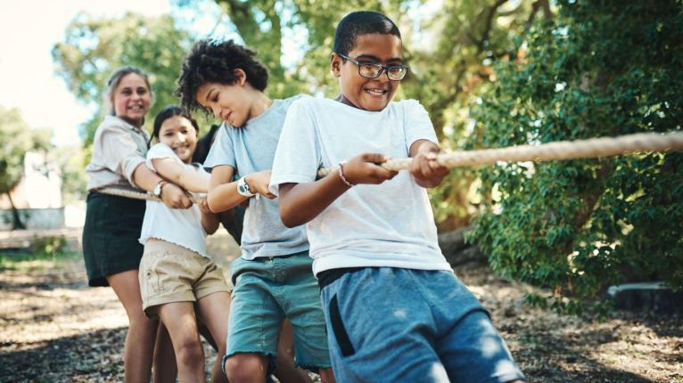 Eine Gruppe von Teenagern, die Tauziehen spielen