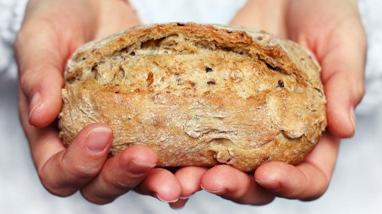 Jemand hält ein kleines Brot in beiden Händen